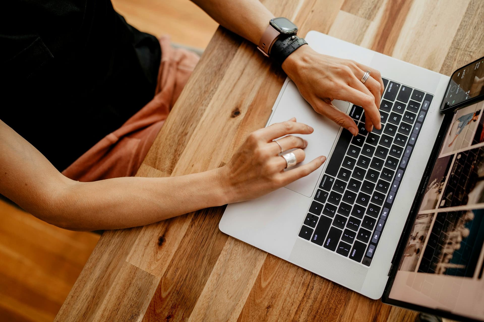 En person skriver på en laptop — den kreative motoren som produserer merkevare-låste varianter.